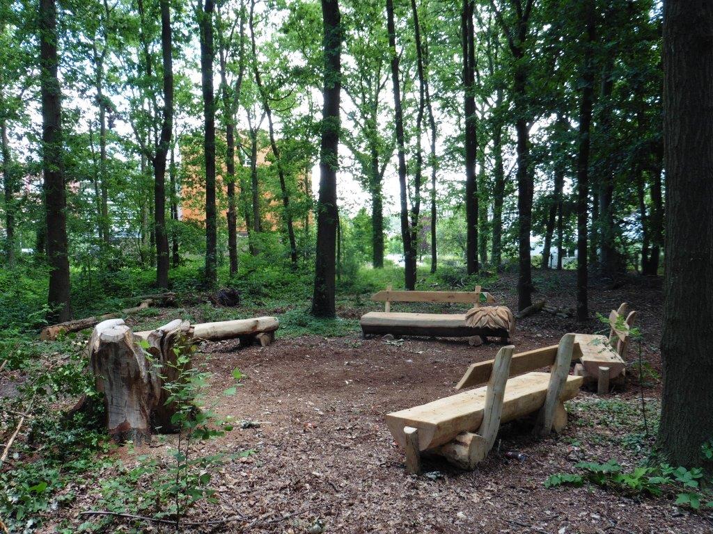 Een wachtkamer in het bos met houten zitbanken
